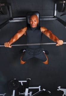 Man Lifting Weights on Bench Press Burning Calories During Workout